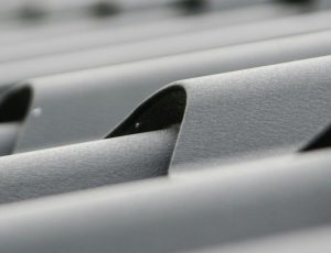 A close-up image of a clean roof tile, showing its smooth, debris-free surface and vibrant color under bright sunlight. A close-up image of a clean roof tile, showing its smooth, debris-free surface and vibrant color under bright sunlight.